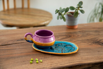 colorful handmade ceramic coffee cup on wooden table