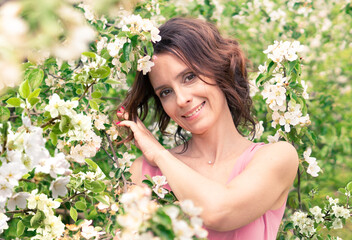 Fototapeta premium A beautiful woman walks through an Apple orchard.
