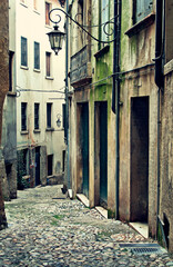 Old european street paved paving stones with lantern. Italy. Scenic landscape old town.