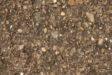 Close up of a lot of different sizes stones that are mixed with cement. The surface of pavement ,...