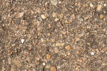 Close up of a lot of different sizes stones that are mixed with cement. The surface of pavement ,...