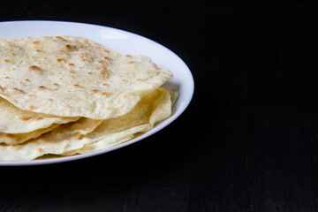 Delicious pita bread made at home in a pan. Thin pita bread on a white plate
