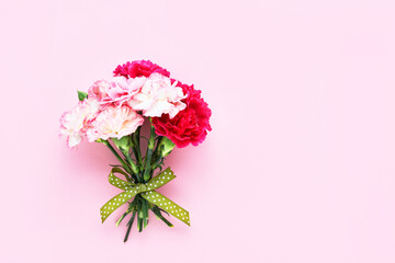 Pink and white carnation flowers bouquet on pink background. Mother's day, Valentines Day, Birthday celebration concept. Copy space, top view