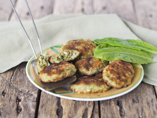 Healthy vegetarian and dietary food. Vegetable and fish cutlets with greens on a wooden background.