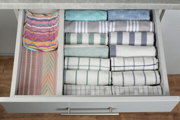 Open drawer with folded towels. Order in kitchen