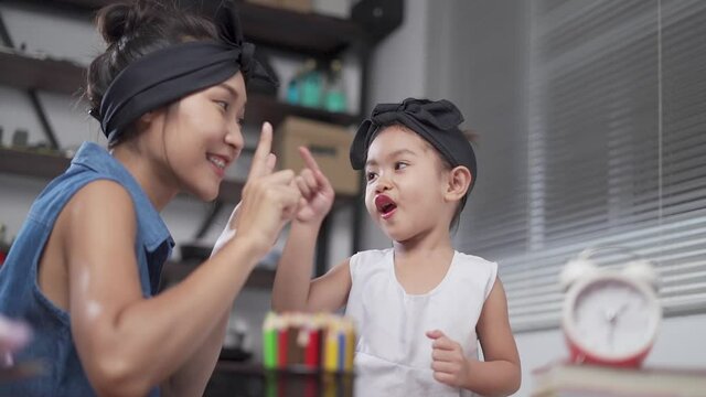 Mother is teaching daughter to count numbers in the house.