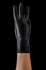 Hand in black gloves showing 3 fingers and counting isolated on black background