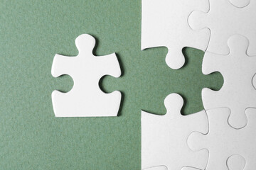 Blank white puzzle with separated piece on grey background, flat lay