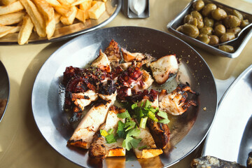 Delicious Cyprus meze - marinated olives, grilled octopus tentacles and french fries