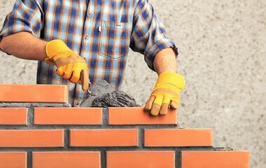 Bricklayer worker installing brick masonry
