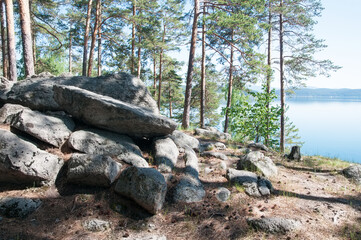 Fototapeta na wymiar Pine forest with boulders on the shore of mountain lake Turgoyak, South Ural, Russia