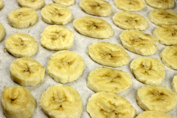 sliced banana chips on parchment paper in the oven