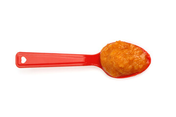 Pumpkin porridge in a spoon isolated on white, natural baby food