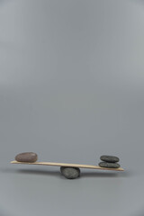 Balance, misbalance and disbalance concept. Zen stones on wooden seesaw. Concept of harmony, calm, yoga and meditation, spa, massage, relax. Zen garden.