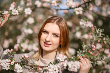 Young girl in a blooming apple orchard