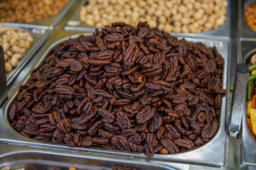 A pile of traditional caramelized, roasted, sweet Pecan nuts, inside a metal can, in the Mahane Yehuda Market, Jeursalem, Israel