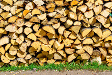 Firewood from various types of wood is stacked in a woodpile