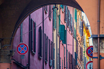 Archway with colorful houses background at old town of Bologna in university area, Italy