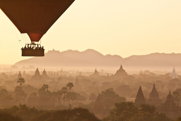 People in the basket of the balloon over Bagan at sunrise, Myanmar. Breathtaking sunrise in Bagan ancient town, Myanmar