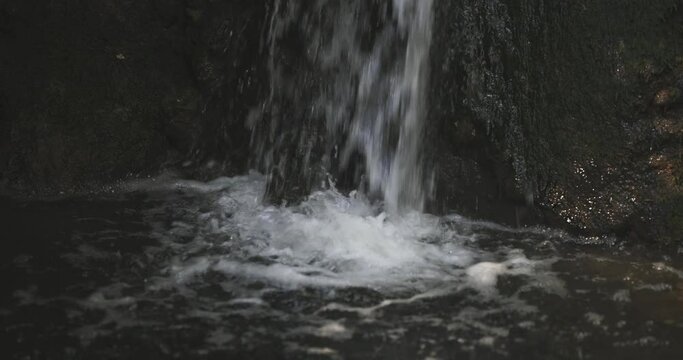 Completely close perspective view from the top of the natural little waterfal.