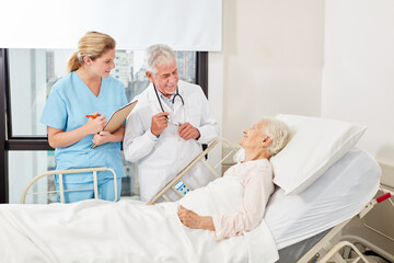 Doctor on the bed of a sick elderly woman