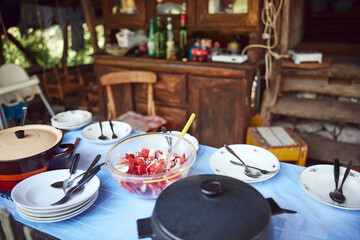 Rustic cottage with outdoor kitchen table ready for summertime lunch.