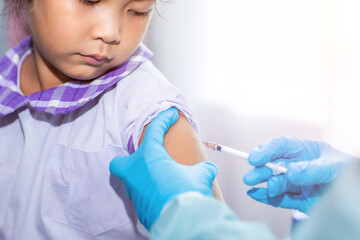 Immunization and vaccination for flu shot, influenza virus, Covid-19 prevention with young child girl in the school having vaccine injection for World immunization week 