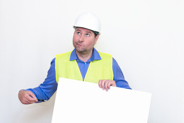 Surprised Engineer man wearing a helmet and reflector vest, standing and holding a billboard. White background.