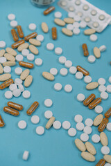 many scattered Colorful medical pills on blue background. Pills are scattered over a blue background. Close up. Medical background.