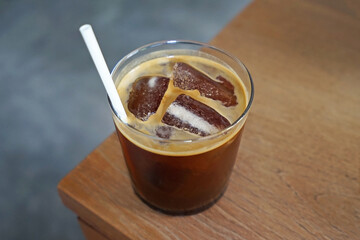 Close up glass of iced black Americano coffee on wooden table
