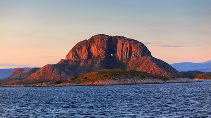 Torghatten mountain alone in the sea of Norway at sunset