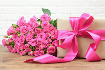 Bouquet of pink roses on a white brick wall background with copy space. The concept of flowers, floristry, holiday