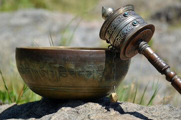 A tibetan bowl and a prayer wheel
