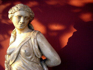 greek roman statue of a woman with red background