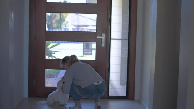 Woman Saying Goodbye To Her Dog Before Leaving The House.