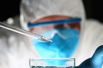 Focused photo on pipette that dropping liquid