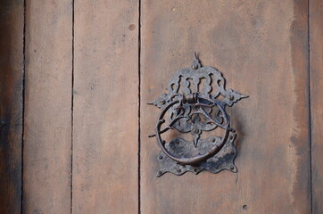 Ancient door knocker in a wood door