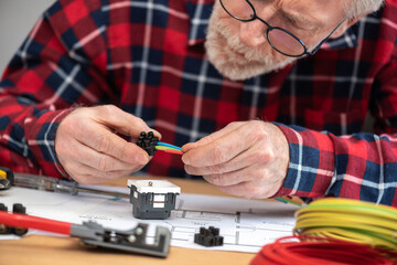 Naklejka premium Electrician connecting wires in terminal block