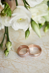 wedding rings lie near bridal bouquet