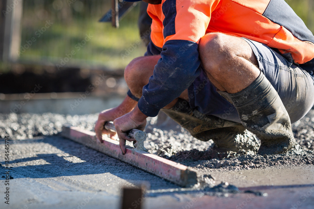 Wall mural pouring and leveling a new concrete slab for a residential house under construction in melbourne aus