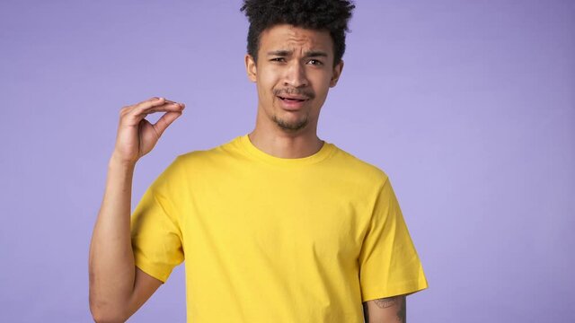Young african displeased guy isolated over purple background showing blah blah gesture