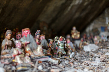 Close up of Buddhist mini statues, focused on Guanyin. Inside a cave of Nanputuo temple park.