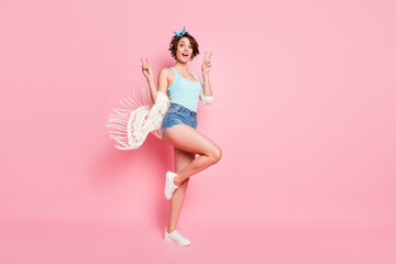 Fototapeta na wymiar Full length body size view of her she nice attractive lovely pretty girlish funky cheerful cheery girl showing v-sign having fun air wind blowing isolated over pink pastel color background