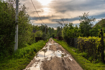 A typical street in the suburban areas in Russia with a dirt road