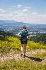Naklejka premium Enjoying the idyllic mountain landscape on Gaisberg: Girl is standing on idyllic meadow and enjoying the view over the far away city of Salzburg