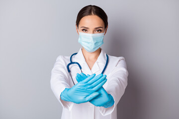 Photo of serious virologist doc lady experienced professional hold crossed palms infected zone wear gloves facial mask medical uniform lab coat stethoscope isolated grey background