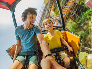 Father and son having fun on rollercoaster