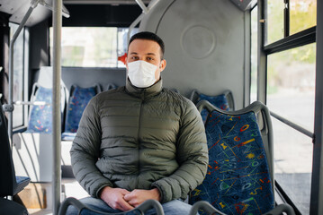 A young masked man uses public transport alone during a pandemic. Protection and prevention covid 19