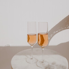 Glasses with rose champagne in sunlight shadows. Happy Birthday / anniversary party holiday celebration. Cheers!