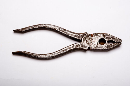 Alicate oxidado y viejo sobre fondo blanco
